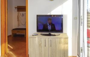 a television sitting on top of a wooden cabinet at Awesome Home In Insel Poel in Insel Poel
