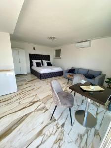 a living room with a bed and a table and chairs at Apartma Hill Portorose in Portorož +5 photos