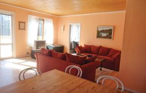 ein Wohnzimmer mit einem roten Sofa und einem Tisch in der Unterkunft Nice Home In Markaryd With Kitchen in Västra Tansjö