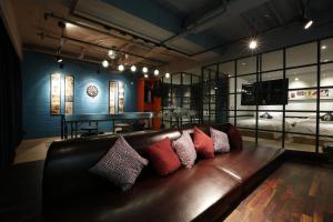 a brown leather couch with pillows in a room at Hotel The Designers Incheon in Incheon