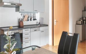 a kitchen with white cabinets and a table and chairs at 2 Bedroom Nice Apartment In Insel Poel-gollwitz in Gollwitz