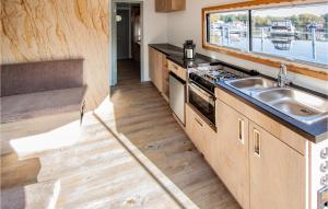 uma cozinha com um lavatório, um fogão e uma janela em Lovely Ship In Hennigsdorf With Lake View em Hennigsdorf