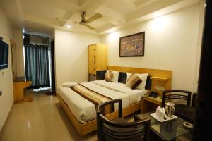 Habitación de hotel con cama y mesa en Hotel Maya 'NEW DELHI', en Nueva Delhi