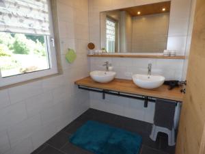 a bathroom with two sinks and a mirror at Alpenchalet Breitspitz in Partenen