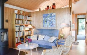 - un salon avec un canapé bleu et des étagères dans l'établissement 4 Bedroom Nice Home In hus, à Åhus