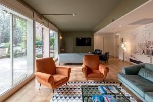 a living room with a couch and chairs and a table at Hotel Millepini in Marina Romea