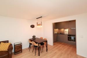 cocina y comedor con mesa y sillas en KoBi Apartments Falkenplatz, en Lucerna