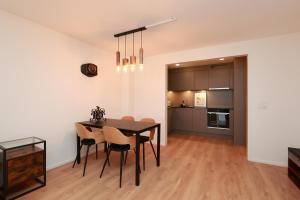 ein Esszimmer und eine Küche mit einem Tisch und Stühlen in der Unterkunft KoBi Apartments Falkenplatz in Luzern