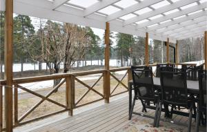 eine abgeschirmte Veranda mit einem Tisch und Stühlen darauf in der Unterkunft 2 Bedroom Beautiful Home In Gunnarskog in Gunnarskog