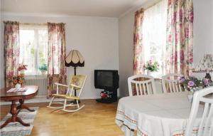 a living room with a table and chairs and a television at 2 Bedroom Beautiful Home In Gunnarskog in Gunnarskog