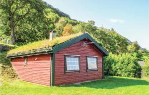 una pequeña casa roja con techo de hierba en Raaen Hytteutleige 1, en Utne