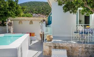 a patio with a pool and a table and a bench at Bohemian Nest - Cheerful 2-Bedroom Villa with pool in Dhavgáta