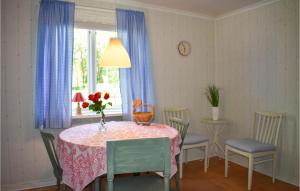 una mesa de comedor con un jarrón de flores. en 1 Bedroom Awesome Apartment In Rnneshytta, en Rönneshytta
