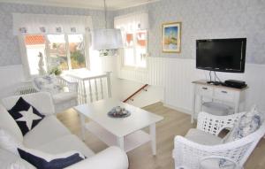 a living room with white furniture and a tv at 3 Bedroom Beautiful Apartment In Kungshamn in Kungshamn