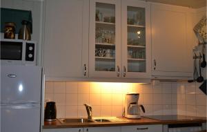 a kitchen with white cabinets and a sink at Beautiful Apartment In Norheimsund With House Sea View in Norheimsund