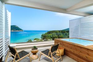 a balcony with a hot tub and chairs at Agorastos Hotel in Koinyra