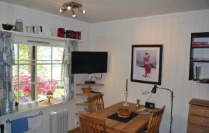 uma sala de jantar com uma mesa e uma televisão em Beautiful Apartment In Norheimsund With House Sea View em Norheimsund