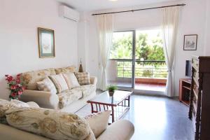 een woonkamer met een bank en een tafel bij TIMON BEACH HOUSE Playa 70m Piscina Parking in Benalmádena