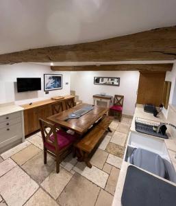 a kitchen with a wooden table and a sink at The Horners - Log burner, Cheshire Village, Parking, Walks, Aga, dogs in Prestbury