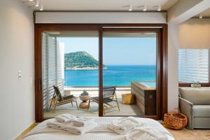 a bedroom with a bed and a view of the ocean at Agorastos Hotel in Koinyra