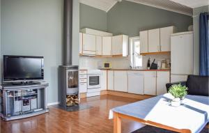NedstrandにあるAmazing Home In Nedstrand With 4 Bedrooms, Sauna And Wifiの白いキャビネット付きのキッチン、リビングルーム(テレビ付)