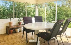 a white table and chairs in a room with windows at Nice Home In Gislaved With Sauna in Gislaved