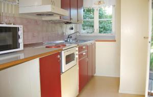 a kitchen with red and white cabinets and a sink at Beautiful Home In Katthammarsvik With 2 Bedrooms in Katthammarsvik