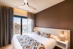 a bedroom with a bed and a large window at Apartamentos Core Suites Valencia in Valencia