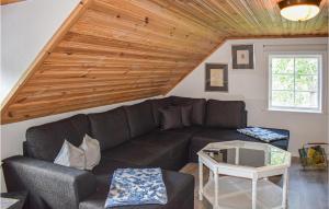 a living room with a couch and a table at Cozy Home In Högsby With Sauna in Aboda