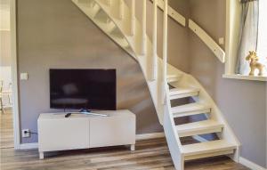 sala de estar con TV y escalera en Cozy Home In Herrng With Wifi, en Herräng