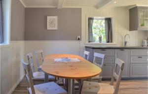 a kitchen with a wooden table and chairs at Cozy Home In Herrng With Wifi in Herräng