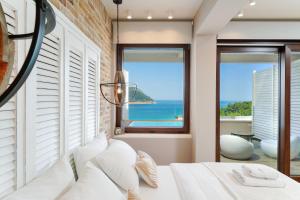 a bedroom with a white bed with a view of the ocean at Agorastos Hotel in Koinyra
