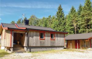 a small building with a staircase next to a forest at 5 Bedroom Gorgeous Home In Tanumshede in Bullaren