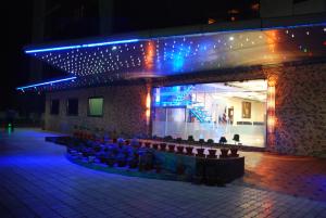 um grupo de pessoas sentadas em frente a um edifício à noite em Wingston A TreeHouse Hotel, Mathura em Matura
