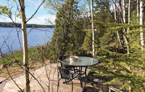 uma mesa e cadeiras num pátio perto de um lago em Lovely Home In Gnosj With House Sea View em Nissafors