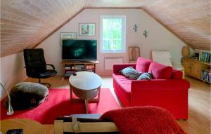 uma sala de estar com um sofá vermelho e uma televisão em Lovely Home In Gnosj With House Sea View em Nissafors