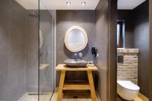 a bathroom with a sink and a mirror at Agorastos Hotel in Koinyra +37 photos