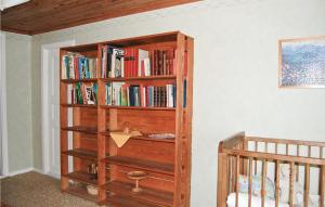 a book shelf in the corner of a room with a crib at Beautiful Home In stra Frlunda With 3 Bedrooms And Sauna in Östra Frölunda