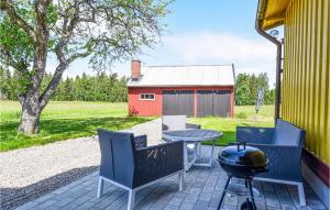 a patio with chairs and a table and a red barn at Cozy Home In Vnersborg With Wifi in Vänersborg