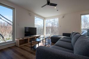 a living room with a couch and a flat screen tv at Yuki no Taki 2 in Niseko