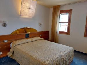 sypialnia z dużym łóżkiem i oknem w obiekcie Hotel Ristorante La Casona w mieście Feltre +37 zdjęć