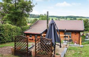 une cabane en rondins avec une balançoire couverte et un parasol dans l'établissement Beautiful Home In Diemelsee With House A Panoramic View, à Diemelsee