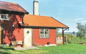 a red house with a bench in front of it at Amazing Home In Strängnäs With Sauna in Aspö