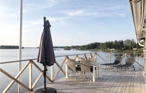 a deck with chairs and an umbrella and water at Beautiful Home In Kristinehamn With 2 Bedrooms And Wifi in Kristinehamn