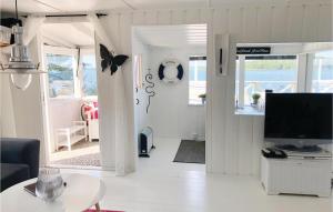 クリスティーネハムンにあるBeautiful Home In Kristinehamn With 2 Bedrooms And Wifiの白いリビングルーム(テレビ、テーブル付)