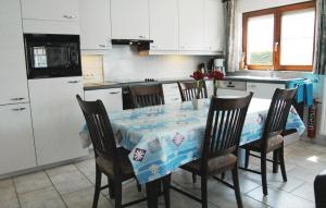 a kitchen with a table with chairs and a refrigerator at Aphrodite in Oostduinkerke