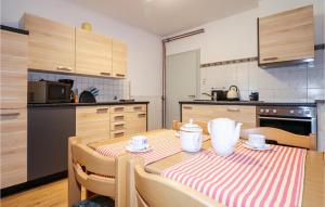 eine Küche mit einem Tisch mit einem roten und weißen Tischtuch in der Unterkunft Amazing Apartment In Techelsberg Wrthersee With House Sea View in Sankt Martin am Techelsberg