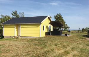 a yellow house with a black roof in a yard at Stunning Home In Lttorp With Wifi in Löttorp