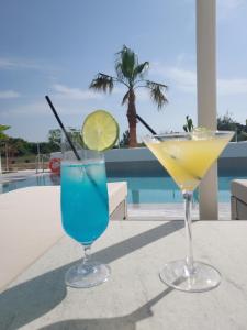 two cocktails sitting on a table next to a pool at Narciso Thassos Luxury Suites in Skala Prinou