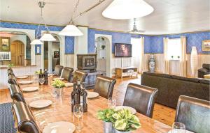 a dining room with a long table and chairs at Amazing Home In Trans With Sauna in Tranås